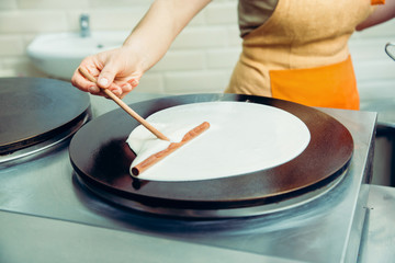 Cooking pancakes. Cooks hands cook pancakes