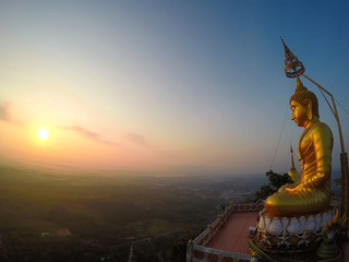 Buddha on top of Wat Tham Seua (Tiger Cave), Krabi, Thailand with sunrise view