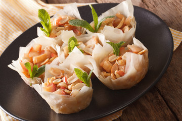 Phyllo dough cups with apples and peanuts closeup. horizontal