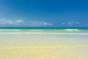 Fototapeta na wymiar Beautiful gentle wave at the shallow beach with blue sky