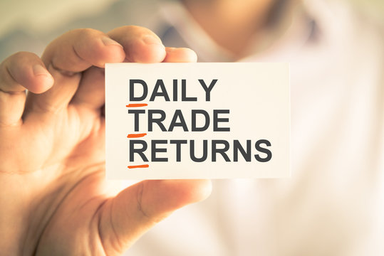 Businessman holding card with DTR DAILY TRADE RETURNS acronym text