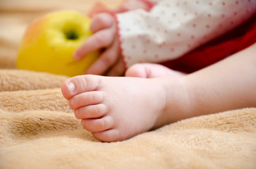 Feet of a little girl on a beige background