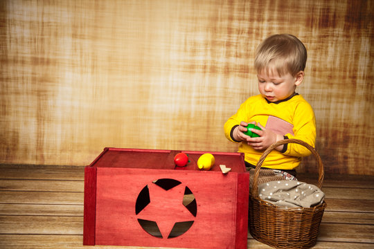 Junge spielt mit Obst aus Holz