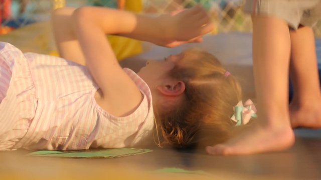 children jump and lie on the trampoline
