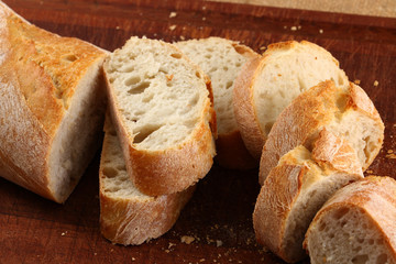 Bread in slices on a dark brown board