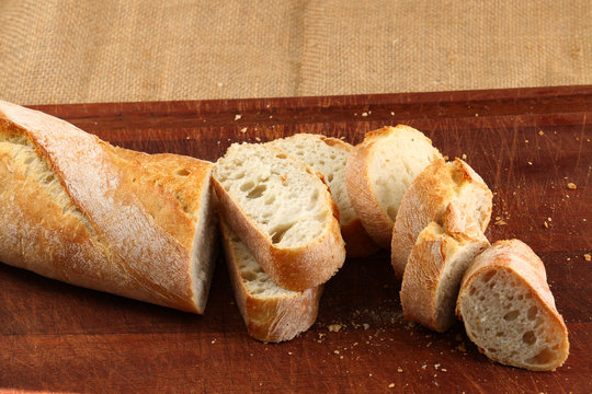 Bread in slices on a dark brown board