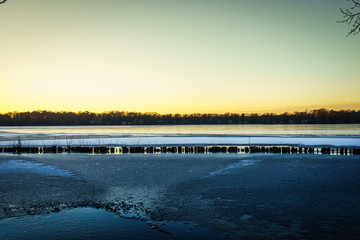 sunset over a snow covered lake in winter