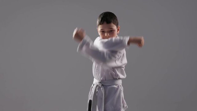 A very young karateka demostrates a self defence kata with several blocking move