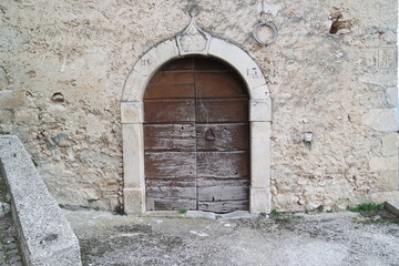 Fototapeta na wymiar old and stone arched wooden door 