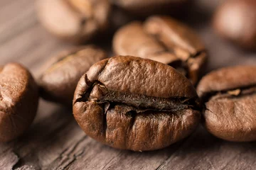 Foto op Canvas coffee beans on wooden board, closeup © puckillustrations