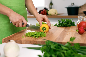 Close up of  woman's hands cooking in the kitchen. Housewife slicing ​​white bread. Vegetarian and healthily cooking concept
