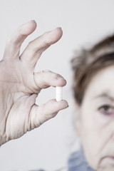 Drug pill kept by a woman with two fingers