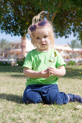 small baby boy with adorable face on green grass