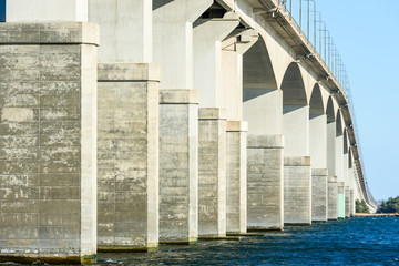 Concrete bridge over water. Gray pillars support the weight of the structure. Vital part of infrastructure and link the island of Oland to mainland Sweden. © imfotograf