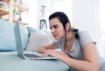 Woman with vision problems using laptop at home