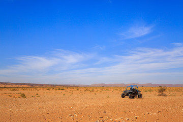 Merzouga, Morocco - Feb 26, 2016: Side view on blue Polaris RZR 800 with it's pilots in Morocco desert near Merzouga. Merzouga is famous for its dunes, the highest in Morocco. - obrazy, fototapety, plakaty