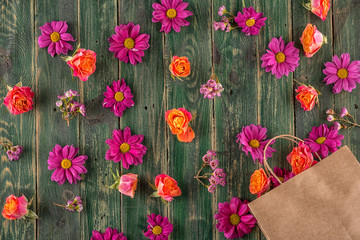 Fototapeta na wymiar paper bag with flowers on wooden background, shopping time or time for sales