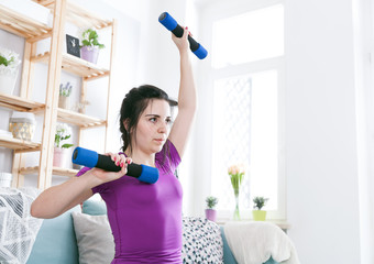Fototapeta na wymiar Young woman exercising at home interior