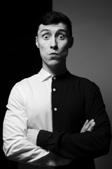 Low key portrait of a man in different shirts in black and white.