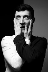 Low key portrait of a man in different shirts in black and white.