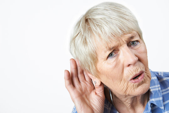 Studio Shot Of  Senior Woman Suffering From Deafness