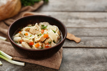 Chicken noodle soup in bowl on wooden table