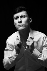 Fototapeta na wymiar Low key portrait of a man in white shirt in black and white.