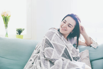 Naklejka premium Young relaxed happy woman while sitting on comfortable sofa, home