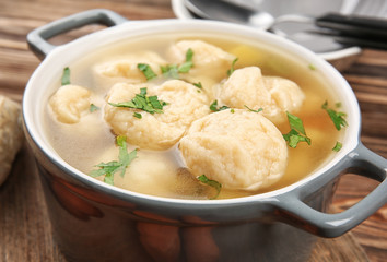 Ceramic pan with delicious chicken and dumplings on wooden cutting board