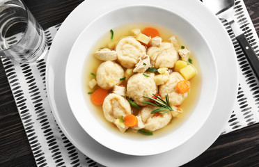 White plate of delicious chicken and dumplings on dining table