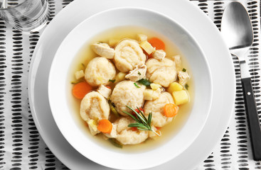 White plate with delicious chicken and dumplings on decorative napkin