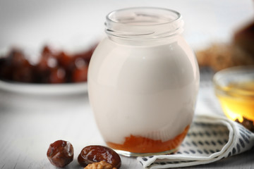 Glass jar with tasty yogurt and jam, closeup