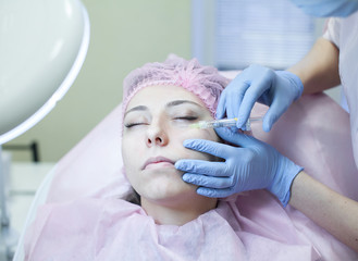 Naklejka premium Cosmetic treatment with injection in a clinic