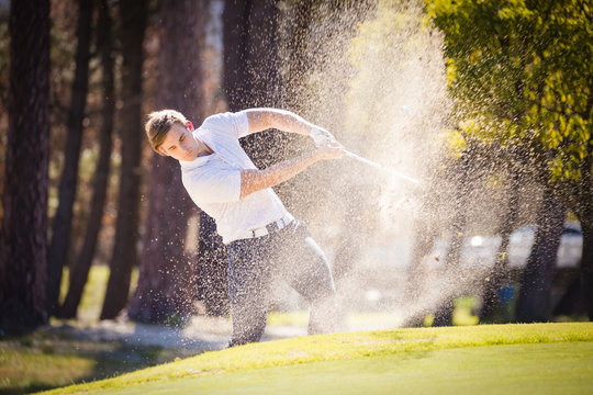 Close up image of a golfer playing a chip shot onto the green on a golf course in south africa.