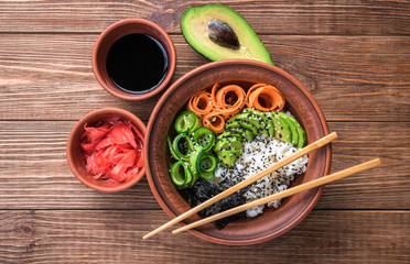 Sushi bowl with seaweed, avocado,  radishes, cucumber and black sesame seeds.