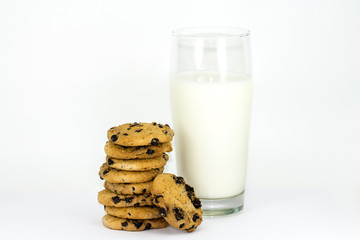 A stack of chocolate chip cookies and glass of milk on a white background.