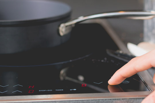 cook is switching on the induction cooktops