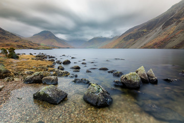 Dramatic view of Wast Water in the Lake District with rocks in foreground.