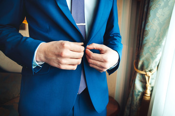 Closeup of man buttoning his jacket, business clothing concept