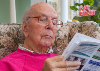 95 years old English man sitting in chair in domestic environment. Health and care concept