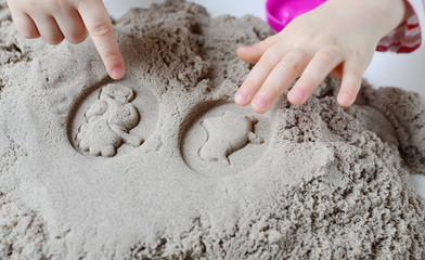 Little baby girl playing with kinetic sand