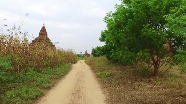 Myanmar. Ride with e-bike on the rural road in Bagan Archaeological Zone with old Buddhist temples.