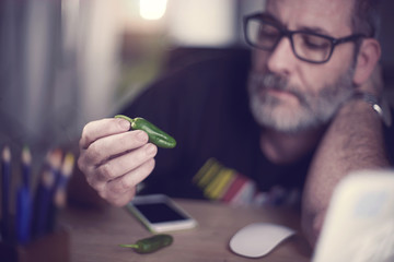 Creative Art Director looks at single green pepper to ad spice to his campain