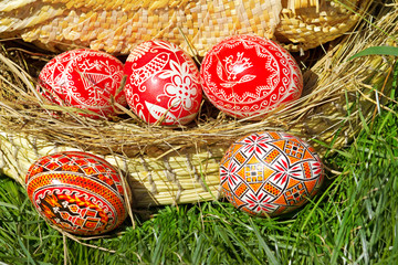 Easter painted eggs in wicker basket outdoors.