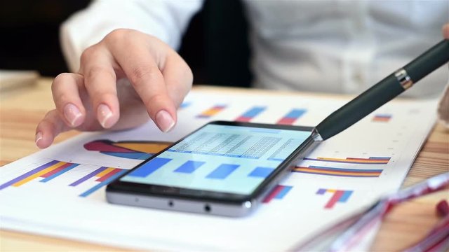 Woman Looking At Graph And Charts On Mobile Phone