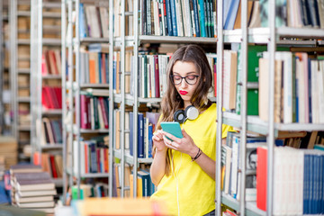 Young student using smart phone at the library