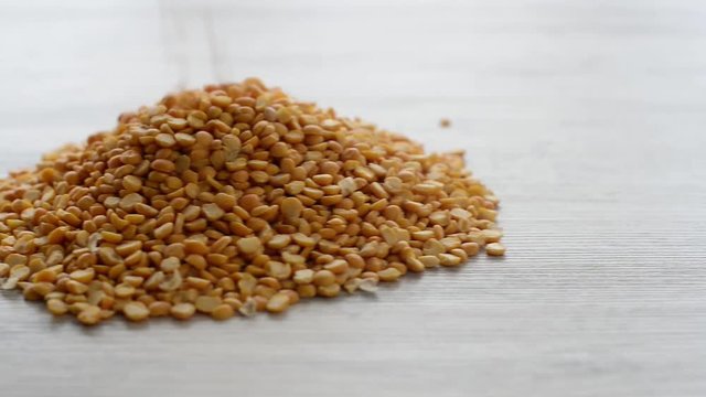 dried peas grains falling on wooden surface