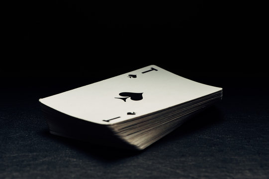 A deck of cards on a black background. The ACE of spades.