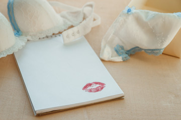 Naklejka premium empty notepad with woman's underwear on wooden table