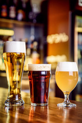 Glass of light and dark beer on a pub with bokeh background
